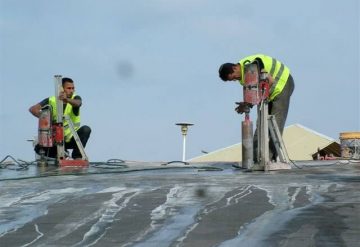 עובדי חברת שחר צדיק בעבודת קידוח בגג בטון