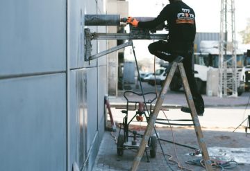 עובד חברת שחר צדיק בזמן קידוח בקיר בטון