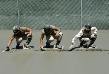 שלושה עובדים עושים שפכטל לרצפת בטון